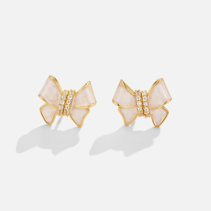 Boucles d’oreilles dorées avec motif floral.
