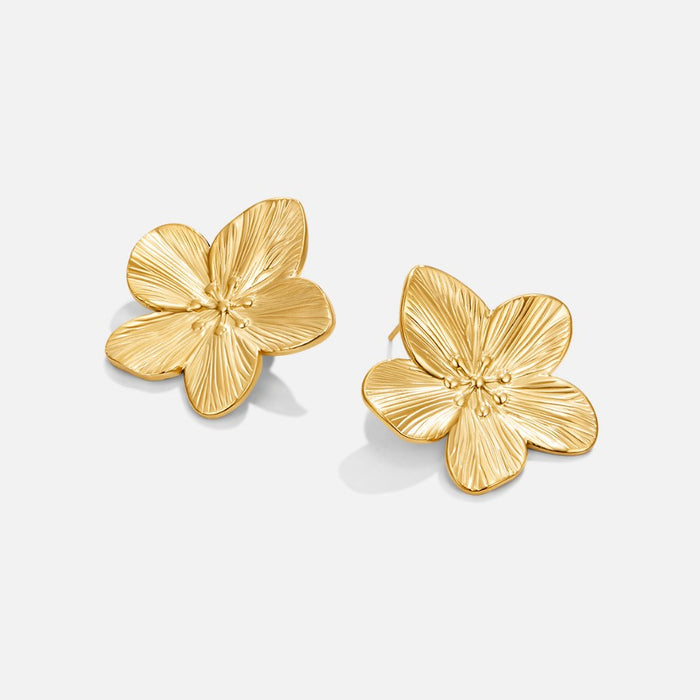 Boucles d’oreilles dorées a forme de fleur.