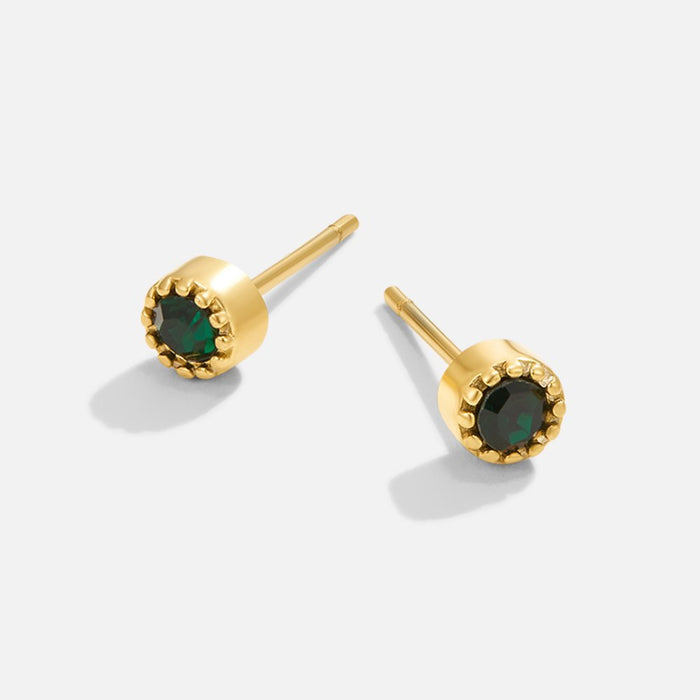 Boucles d’oreilles dorées avec pierre verte.