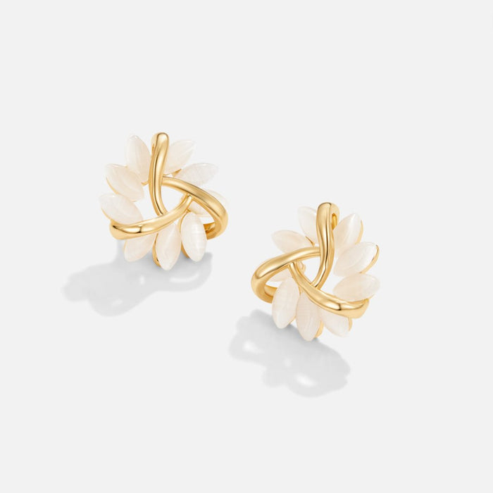 Boucles d’oreilles dorées avec détails floraux.